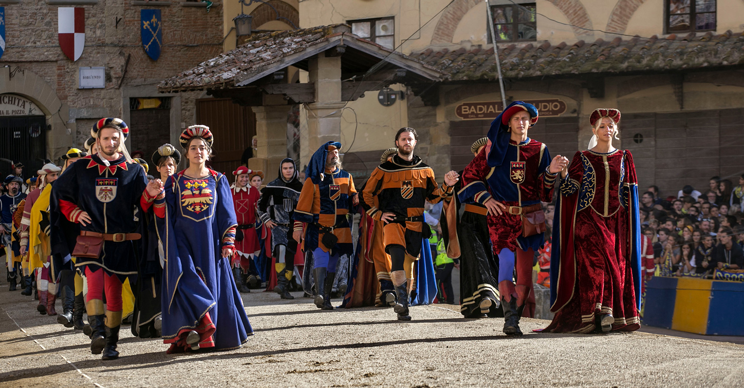 Costumed representatives of Arezzo's four quarters processing across Piazza Grande before the Giostra del Saracino